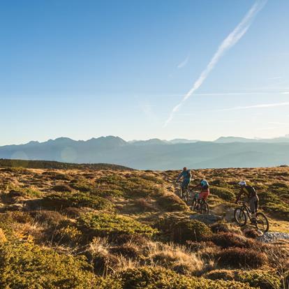 Tre persone fanno con il mountain bike il giro del Monte San Vigilio.